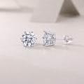 Pair of silver stud earrings with clear gemstones on a light gray background