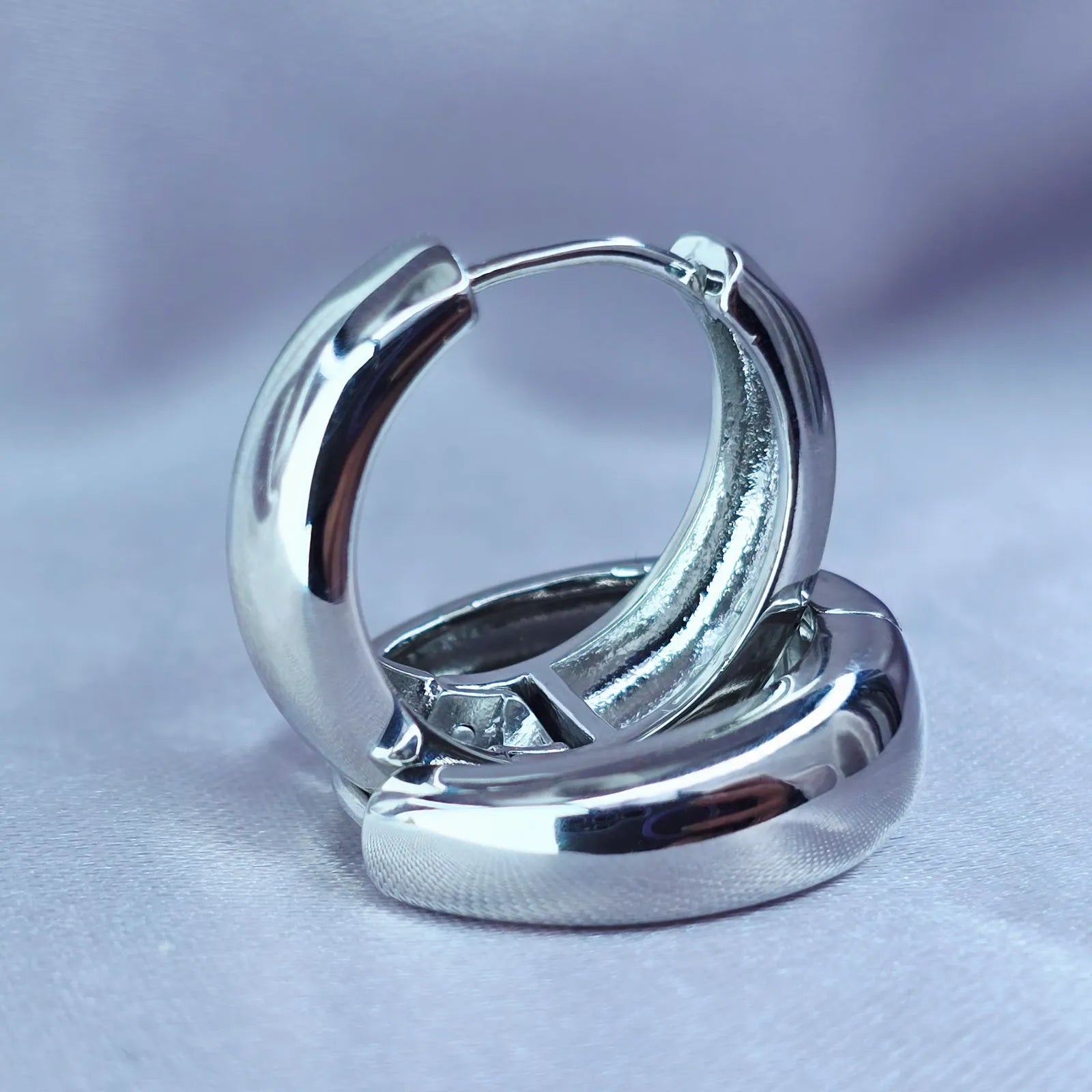 Pair of silver hoop earrings on a light gray background