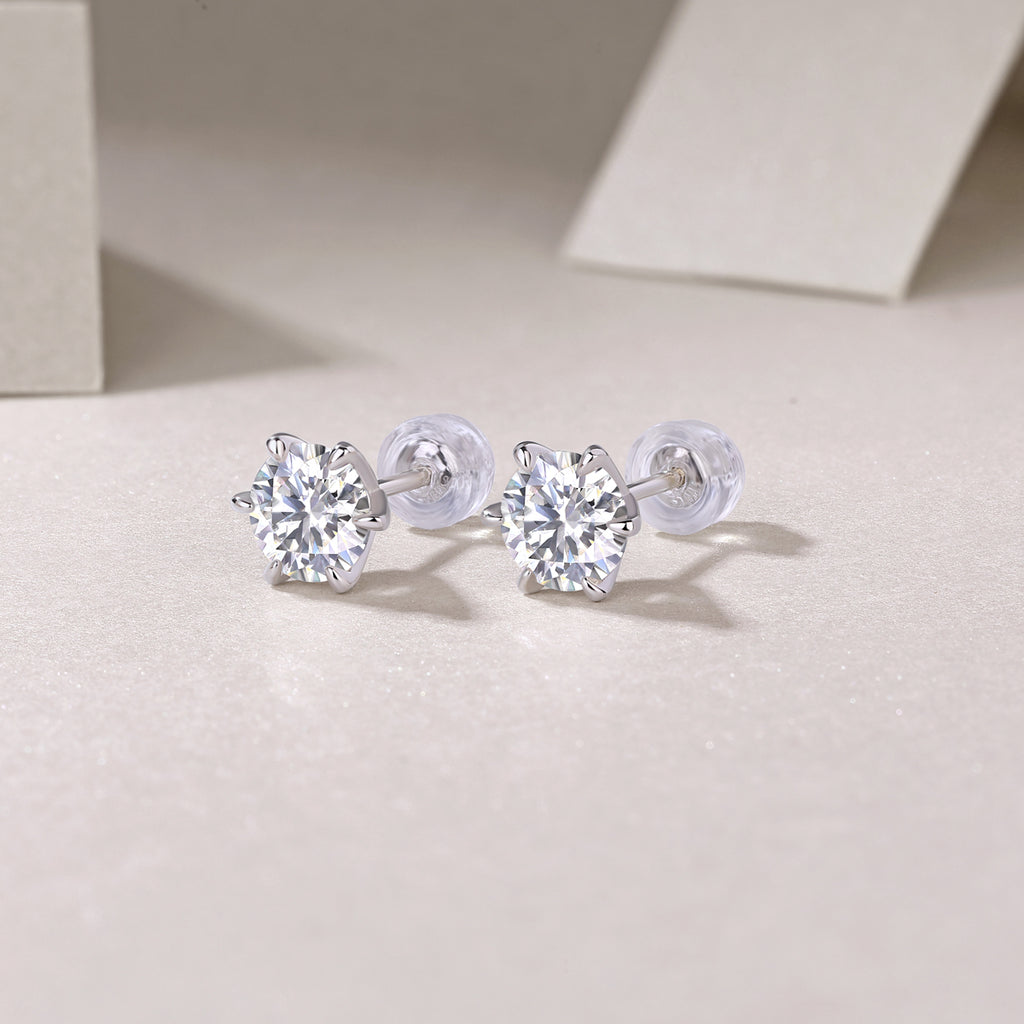 Pair of silver stud earrings with clear gemstones on a light background