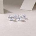 Pair of silver stud earrings with clear gemstones on a light background