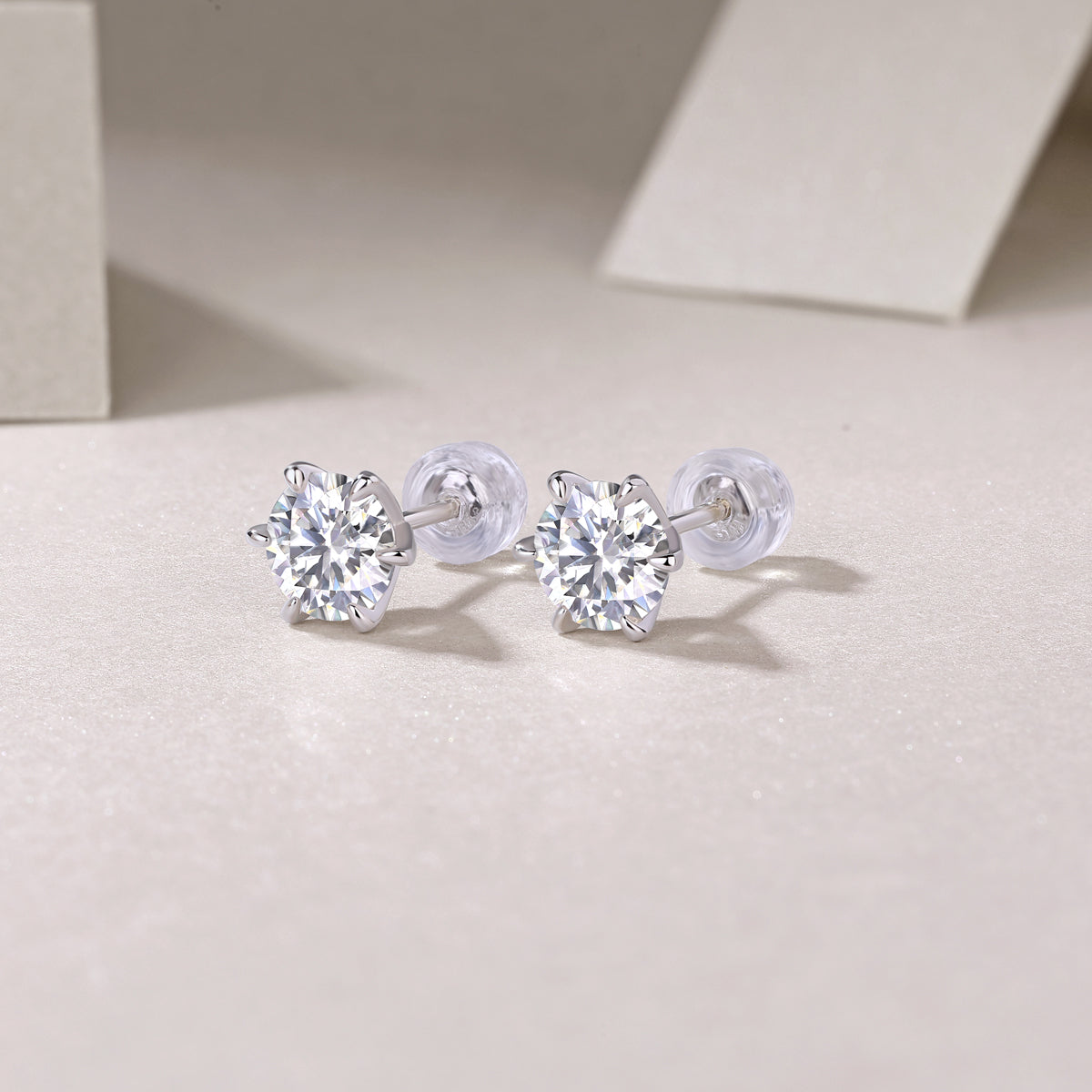 Pair of silver stud earrings with clear gemstones on a light background