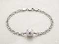 Silver chain bracelet with a round clasp on a light gray background