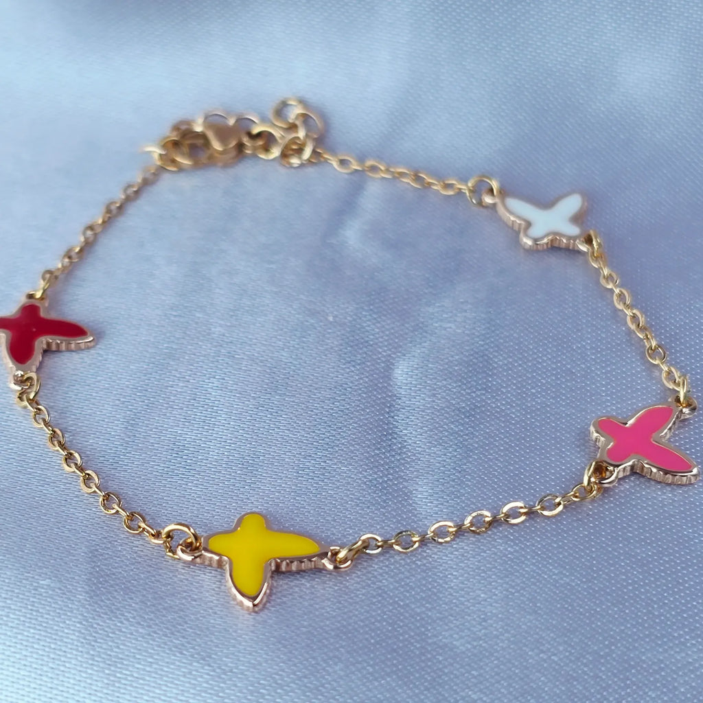 Gold bracelet with colorful butterfly charms on a light blue background
