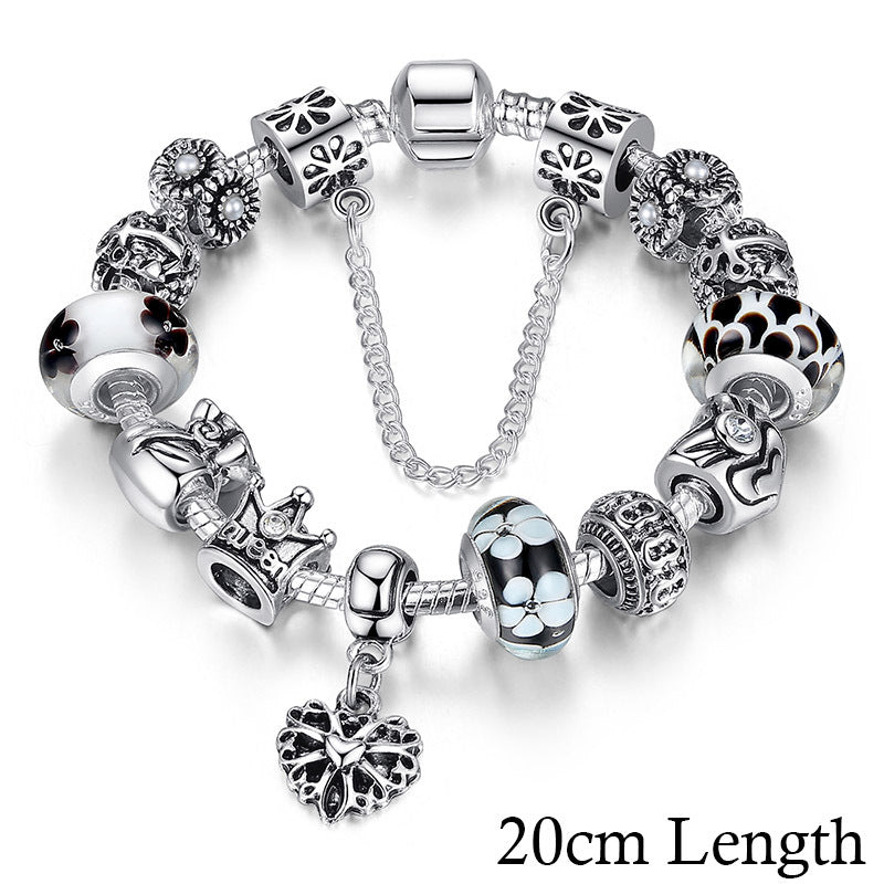 Silver bracelet with various charms on a white background