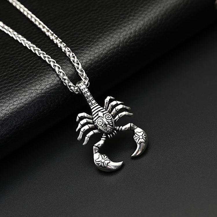 Silver scorpion pendant necklace on a dark surface