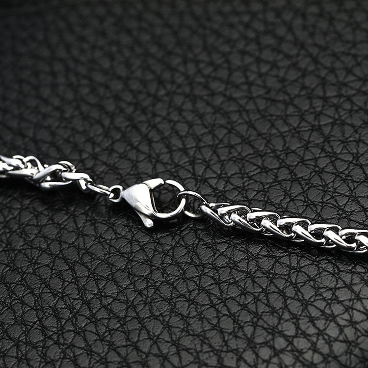 Silver chain bracelet on a black textured surface
